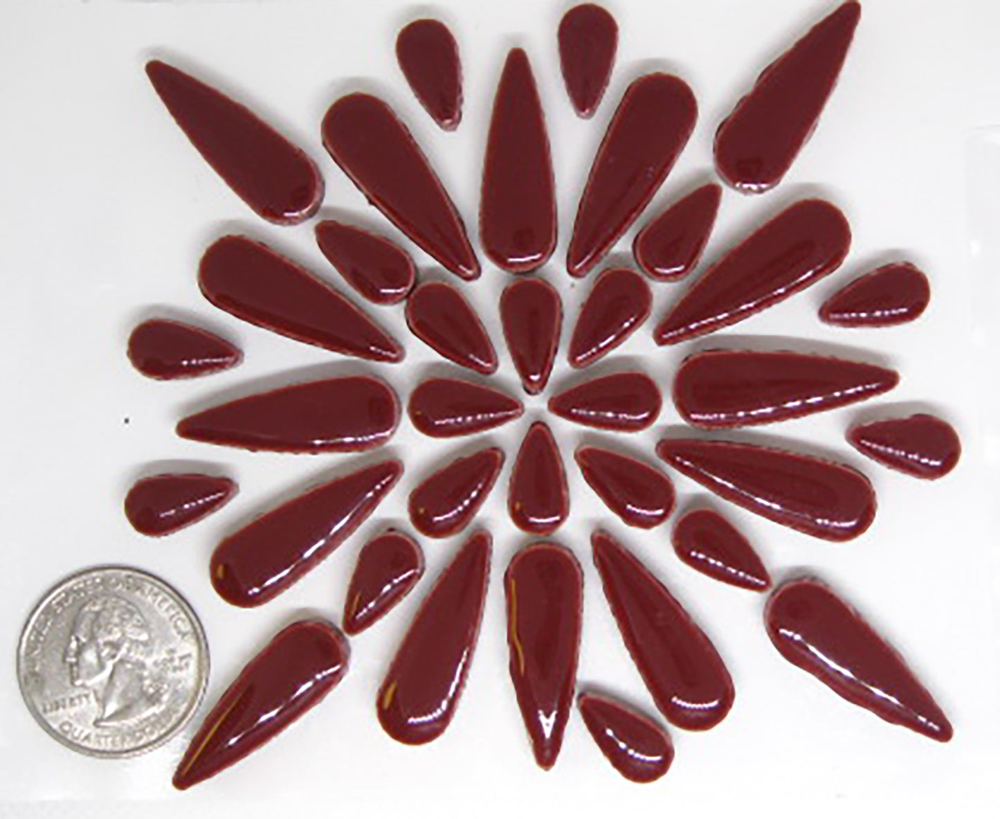 2 ounces of glossy wine red ceramic teardrop tiles arranged in a pattern to showcase product quantity.