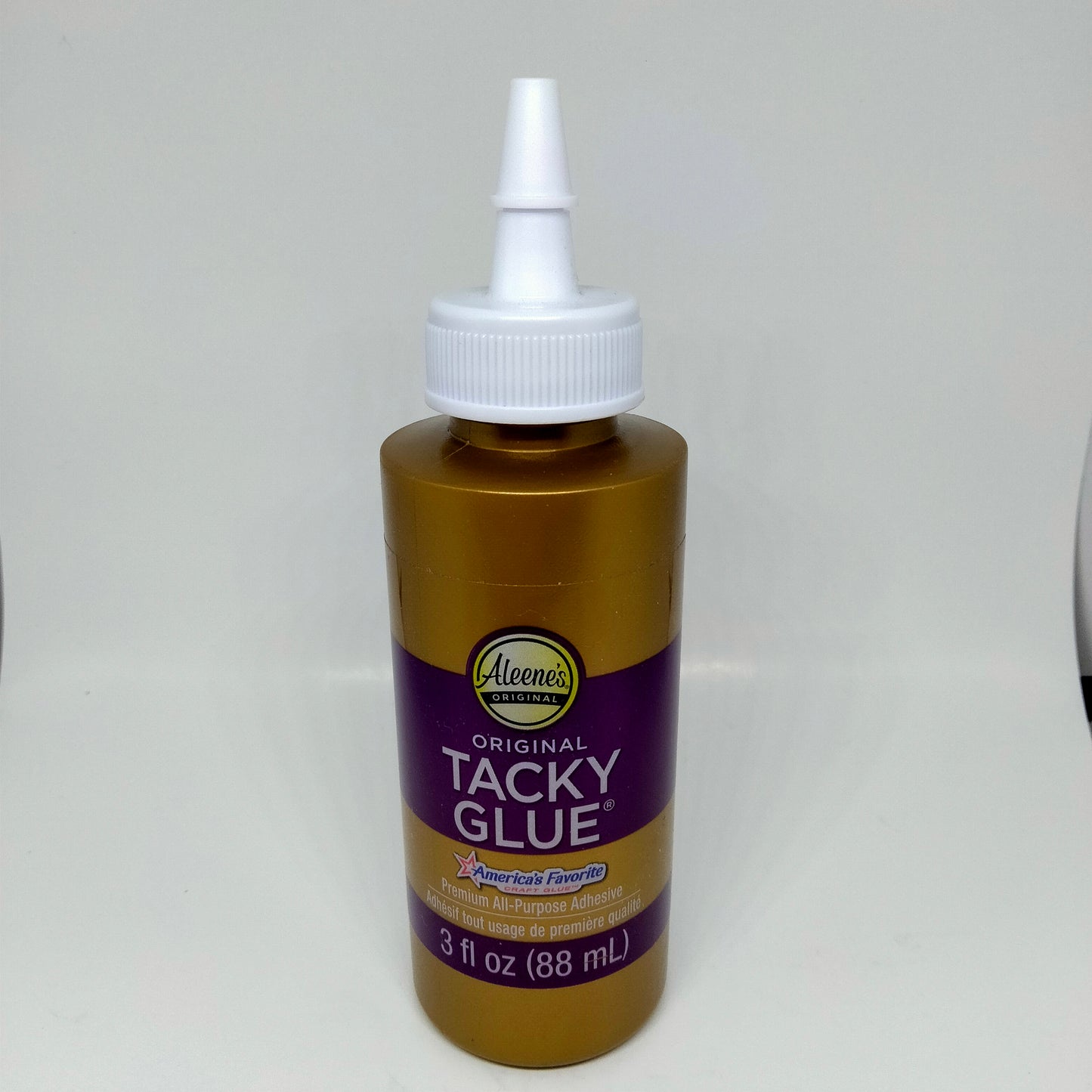 A 3 oz bottle of Aleene's Original Tacky Glue with a white cap, labeled for various uses including crafts and DIY projects.