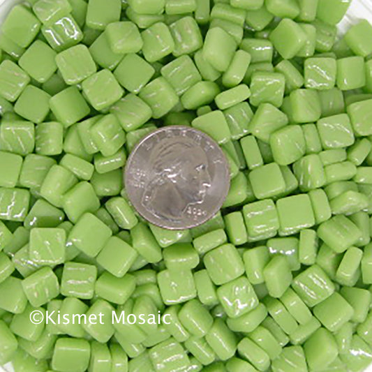 8mm apple green mosaic tiles with a shiny finish, featuring a quarter for scale, showcasing vibrant color and texture for creative projects by Kismet Mosaic.

