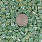 8mm Sea Green mosaic tiles arranged with a quarter for scale, showcasing vibrant colors and iridized finish, ideal for creative projects by artists and DIY enthusiasts.
