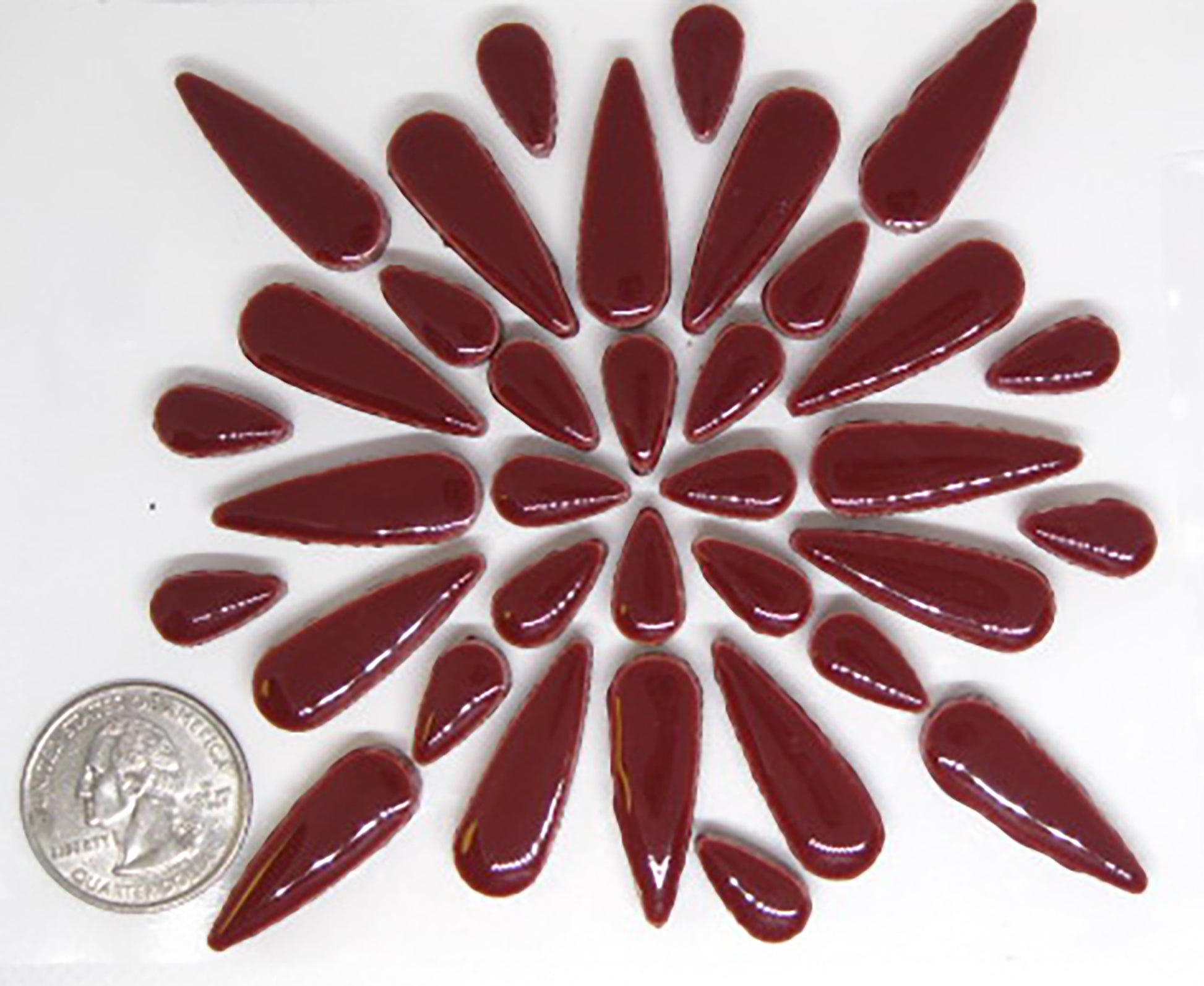 2 ounces of glossy wine red ceramic teardrop tiles arranged in a pattern to showcase product quantity.