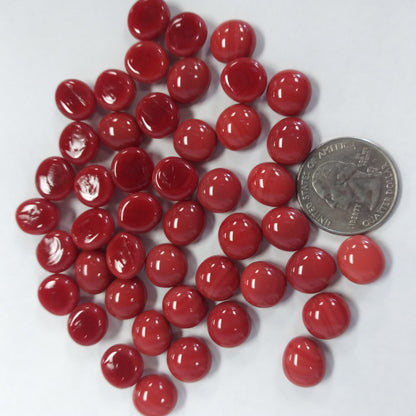 A collection of red glossy mini glass gemstones with a domed surface and flat back, used for mosaics and crafts.