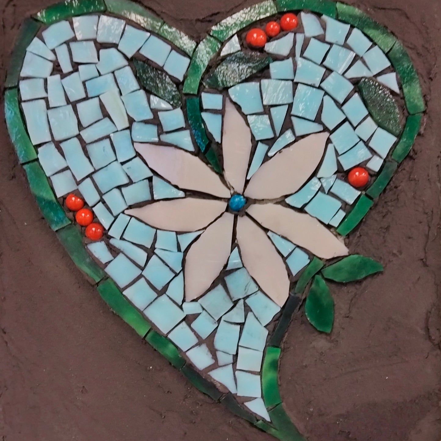 Mosaic heart with a flower design on a black background